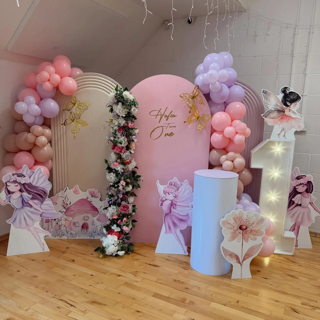 A blush and lilac balloon arch with plinths and florals