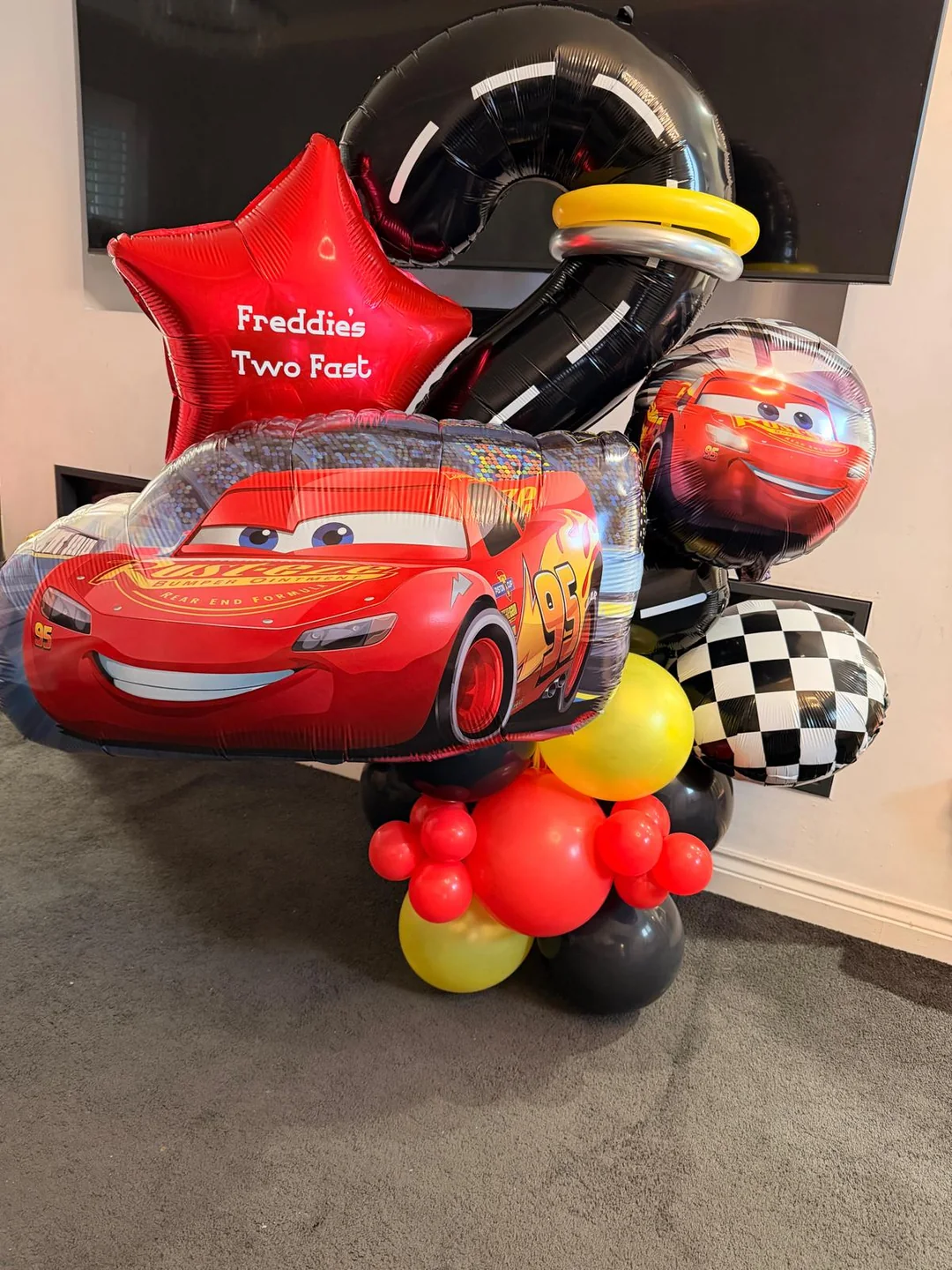 A Lightning McQueen balloon bouquet with a personalised star for a second birthday