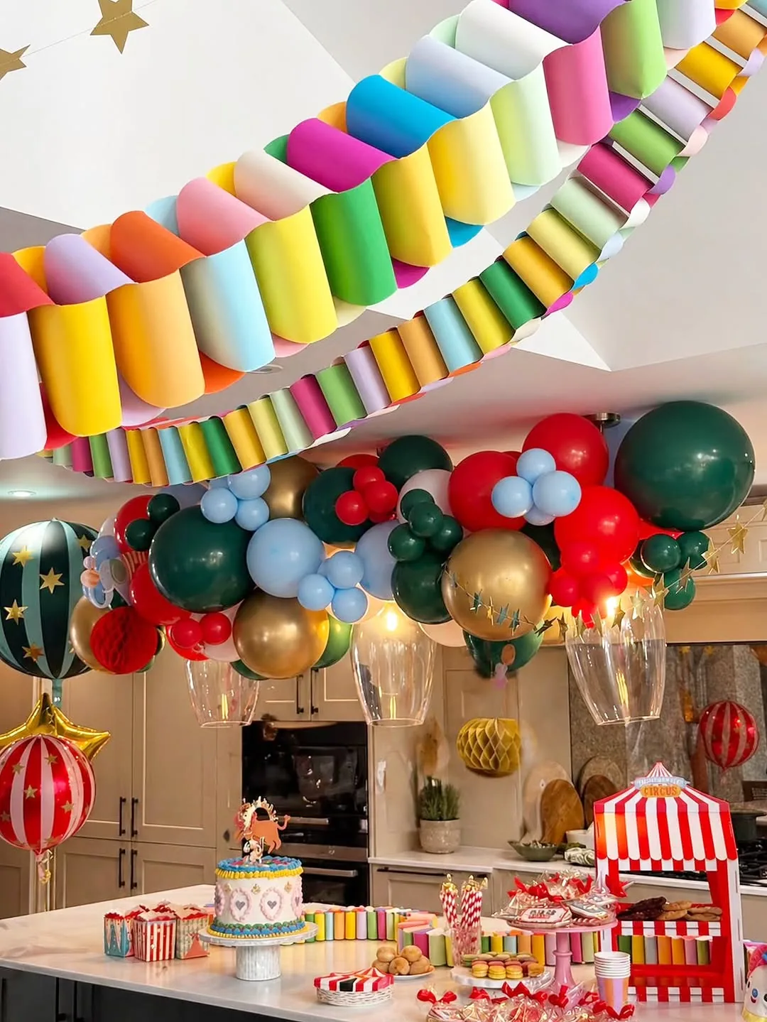 A rainbow balloon garland running across a ceiling
