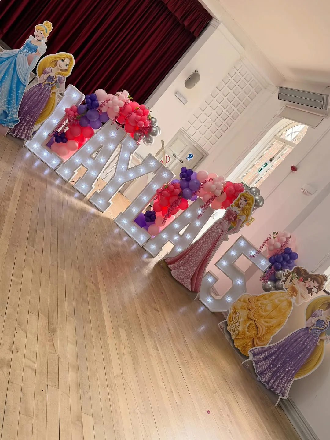 Light up letters dressed with flowers along the top