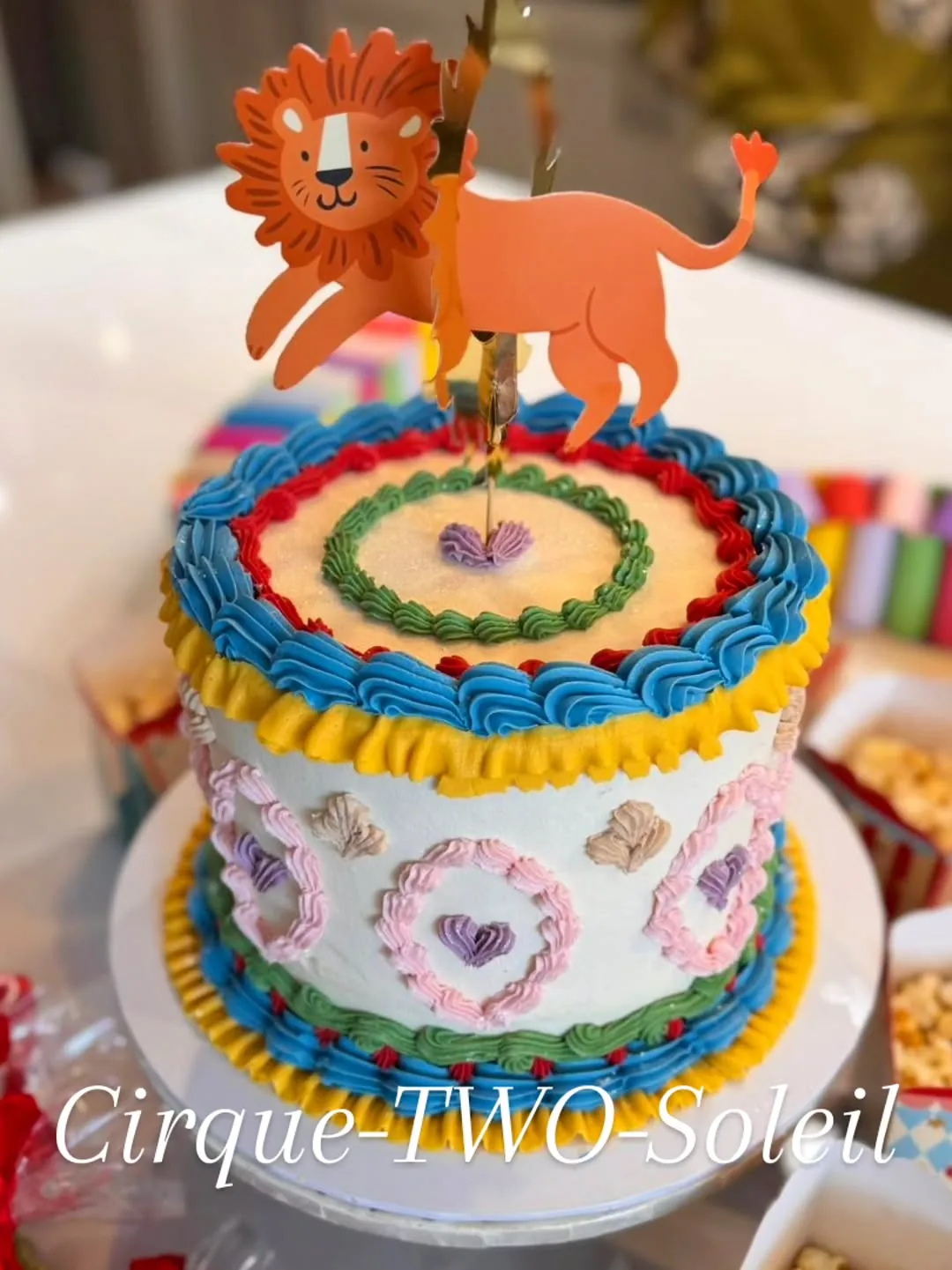A rainbow tiered birthday cake with animal toppers