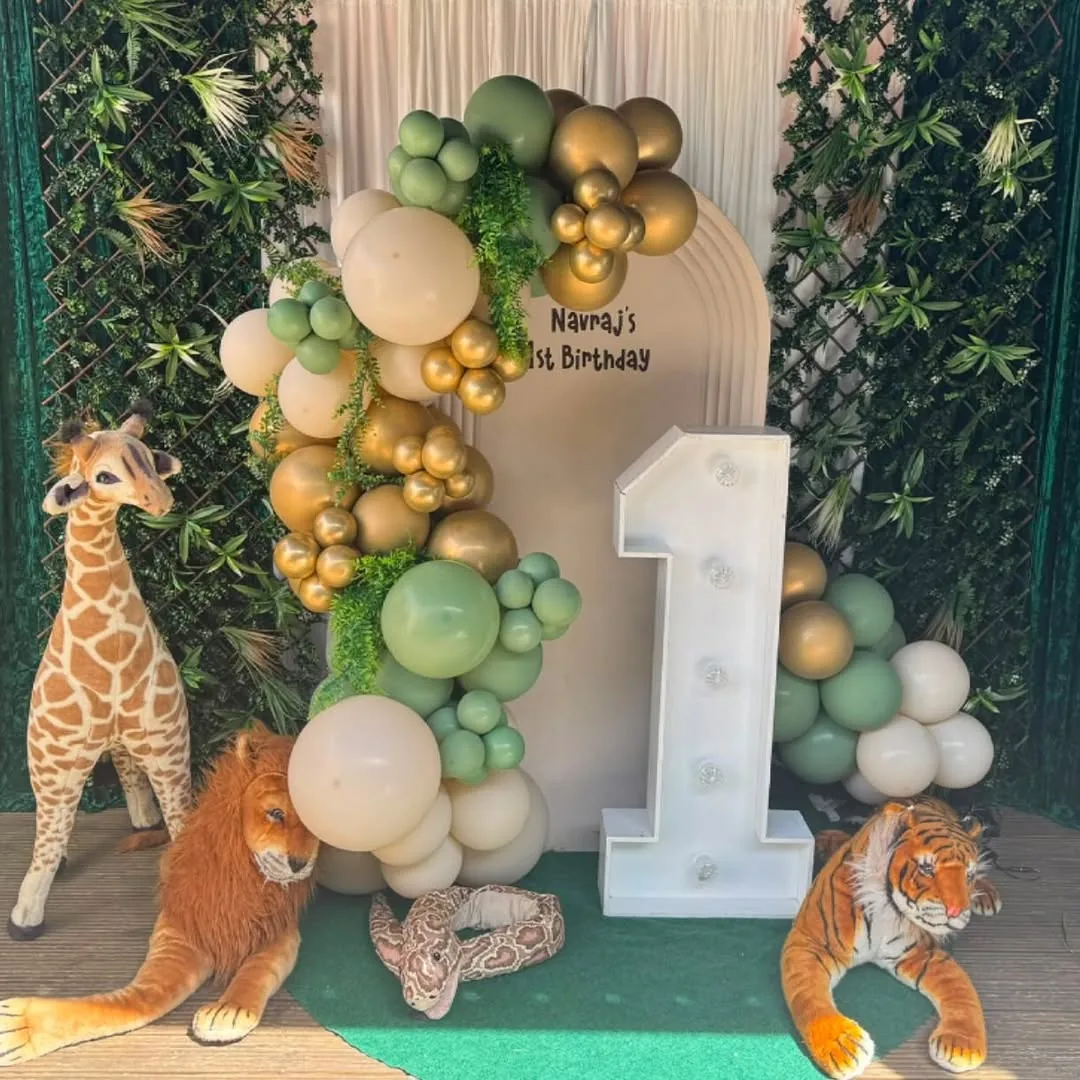 A greenery wall with a light up one and a sage garland
