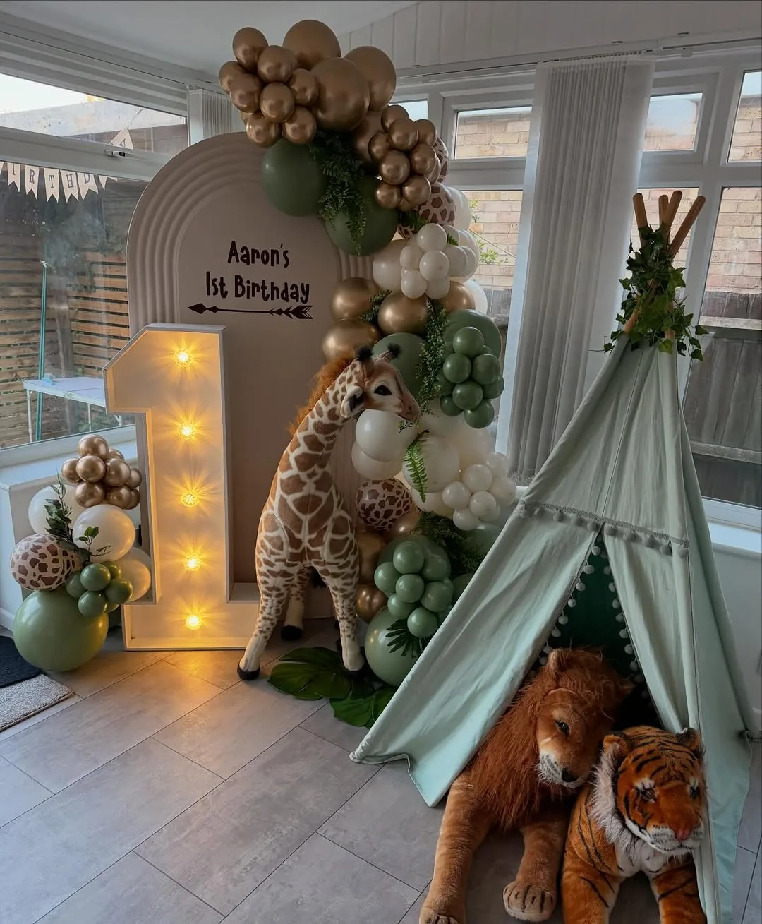 A safari themed first birthday with a teepee and garland
