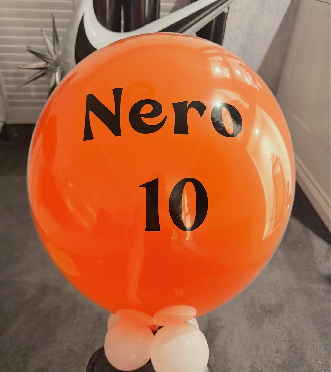 A black and orange tenth birthday setup with foil numbers