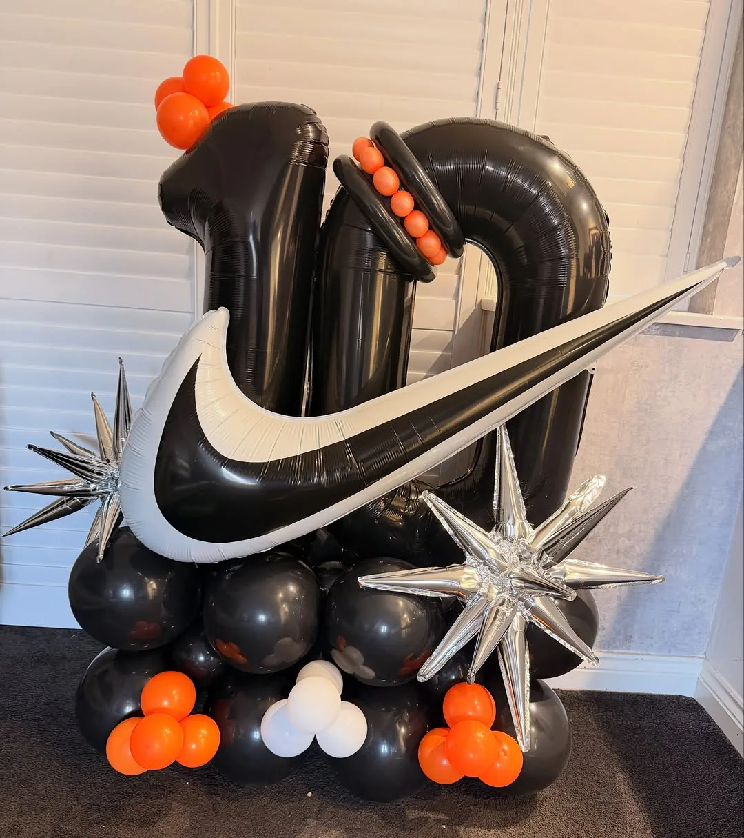 A black and orange tenth birthday balloon display
