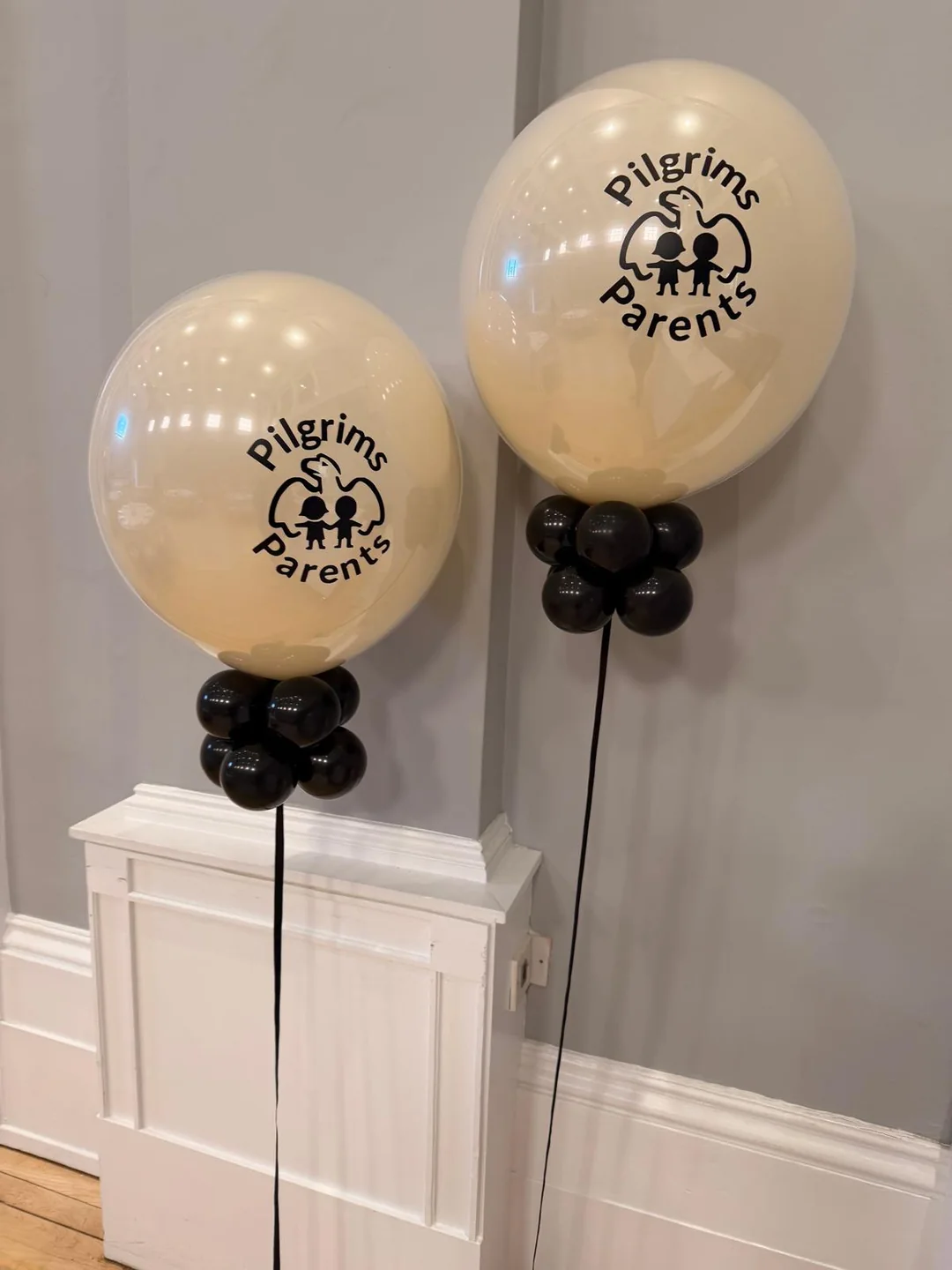 Latex balloons printed with a company logo, weighted on black balloon bases