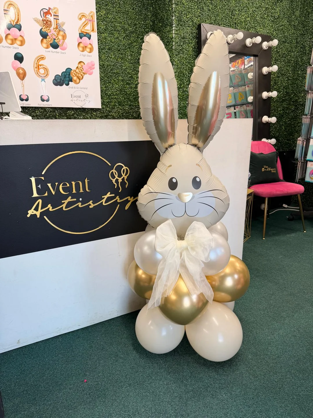 A bunny balloon sculpture standing beside the Event Artistry counter in the shop