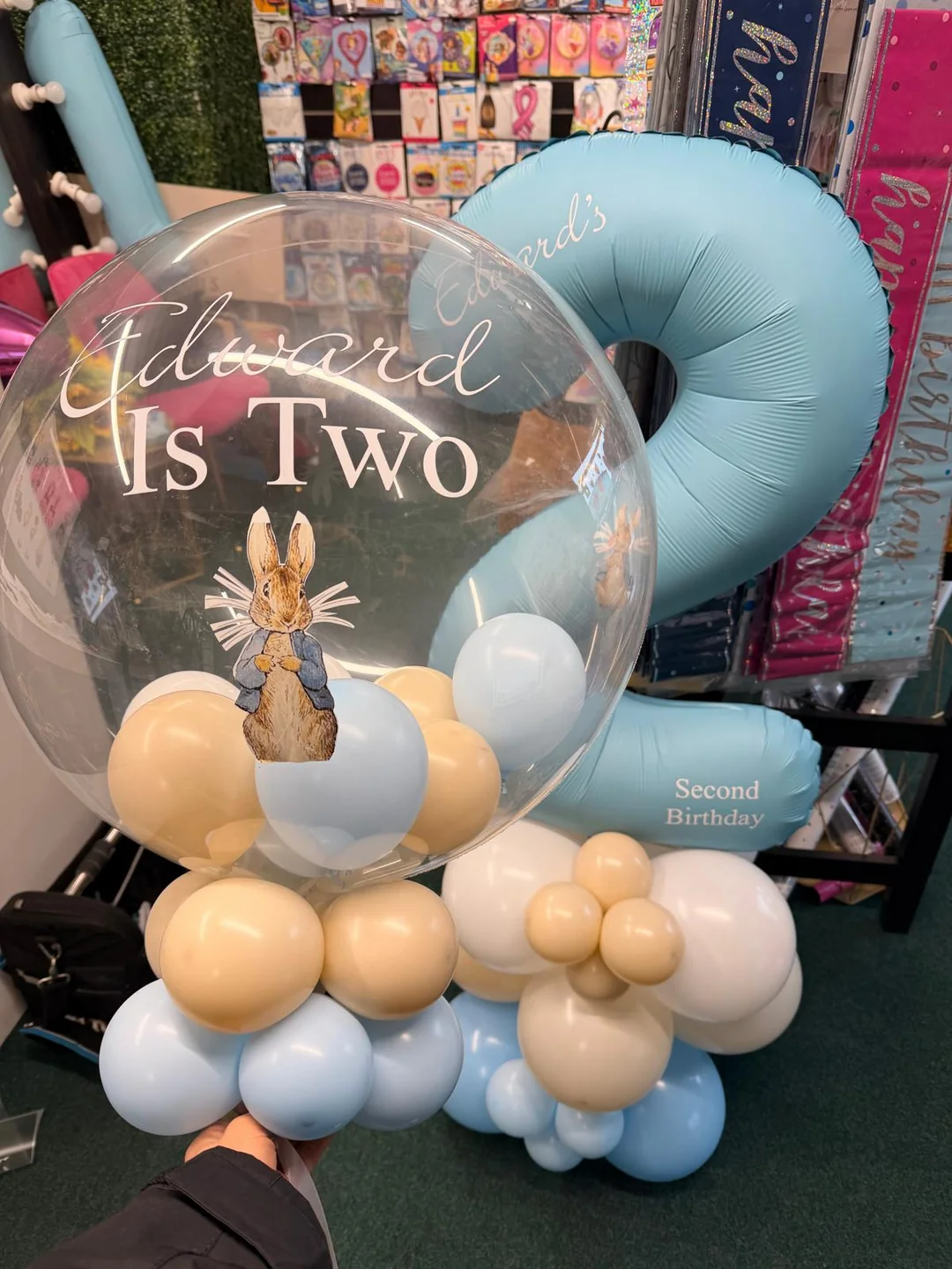A personalised Peter Rabbit bubble balloon on a blue and cream balloon stack