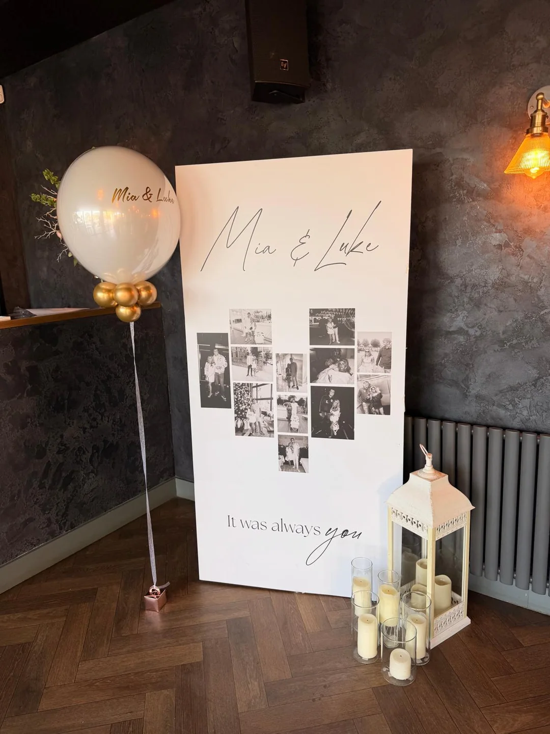A wedding photo board with a personalised bubble balloon, a lantern and candles